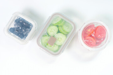 Glass boxes with vegetables on a white background close-up top view.