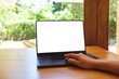 © Farknot Architect - Mockup image of a woman using and touching on laptop computer with blank white desktop screen on wooden table