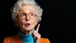 © Atchariya63 - Elderly woman with white hair and orange glasses, expressing a surprised thought.