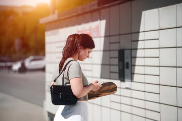 Young woman picking up delivery outdoors