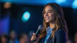 © Ruslan - Smiling businesswoman with microphone giving speech on stage during conference