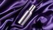 © Wimon - Matte silver cosmetic bottle lying on dark plum chiffon fabric, with subtle lighting emphasizing the contrast between the fabrics softness and the sleek packaging.