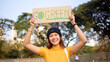 © ChayTee - Go green Gen Z woman asia young people smile looking at camera showing save the earth planet world care banner poster sign in city nature tree public park. Protect future asian hope net zero waste.