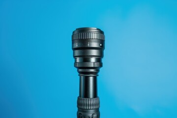 Close-up of a camera lens against a bright blue background showcasing intricate design and craftsmanship