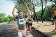 © Odua Images - marathon runner crossing finish line with hands up gesture