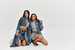 © LIGHTFIELD STUDIOS - Two pretty young women showcase fashionable denim looks, exuding confidence and creativity.