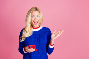 Wall Mural - Photo of pretty lady hold smart phone empty space wear blue sweater isolated on pink color background