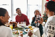 © LIGHTFIELD STUDIOS - A group of friends shares a festive Christmas meal filled with laughter and good cheer.