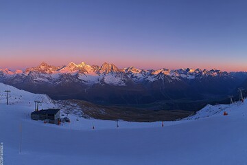 On a mountain near Lenzerheide, Switzerland, a sunset was captured while the snow was being blown away by a wind storm in winter