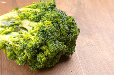 Raw fresh broccoli on old wooden table.