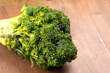 Raw fresh broccoli on old wooden table.