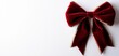 © JP STUDIO LAB - A classic red velvet Christmas bow with golden trim, plush and regal holiday ribbon, timeless festive decoration, isolated on white background