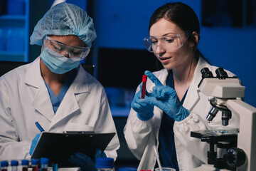 Wall Mural - team of biochemical research scientists working with a microscope for vaccine development