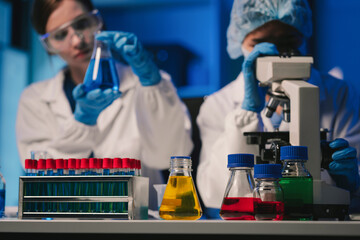 Wall Mural - team of biochemical research scientists working with a microscope for vaccine development