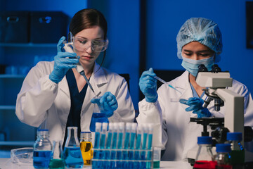 Wall Mural - team of biochemical research scientists working with a microscope for vaccine development