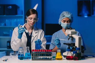 Wall Mural - team of biochemical research scientists working with a microscope for vaccine development