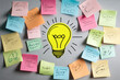 © Alexandra - Big yellow light bulb drawing is surrounded by colorful sticky notes with scribbles representing a brainstorming session