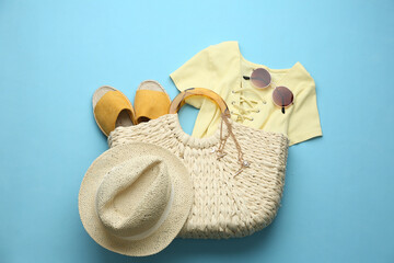 Poster - Flat lay composition with woman's straw bag on light blue background