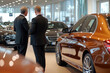 © Olga - Сonsultant at car dealership shows car to buyer