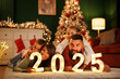 © Impact Photography - Parents and children holding numbers 2025 while spending New Year's Eve at home