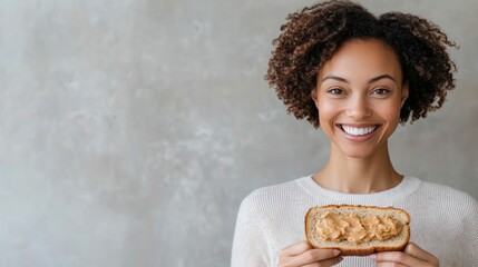 Plus size female model with curly hair smiling while enjoying a slice of whole grain toast topped with almond butter and banana showcasing a healthy and nutritious lifestyle choice