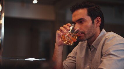 Sitting smart man drinking alone of cocktail Old fashioned waiting friends or couple at bokeh lighting at luxurious beverage counter nightclub at pub and restaurant on Friday meeting night. Vinosity.