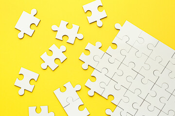 Poster - White puzzle pieces on yellow background, top view