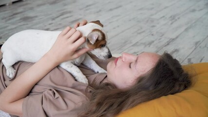 Wall Mural - Teen girl playing with puppy dog at home