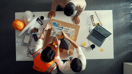 Close up of civil engineer hand holding blueprint while working together to plan building construction by using house model and shaking hand or making a deal or contract with manager. Alimentation.