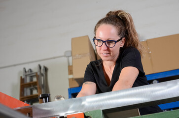 Female carpenter cutting wood in her workshop