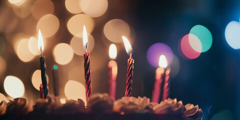 Poster - Lit birthday candles burning on cake with festive bokeh background