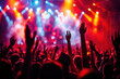 © oksa_studio - crowd raises their hands at a lively concert, illuminated by colorful stage lights, creating a dynamic atmosphere of energy and excitement.