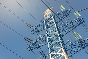 high voltage power line, network of high voltage electricity cables with a blue sky as a background