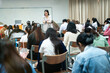 © EduLife Photos - A teacher carefully monitors students taking an exam in a classroom, ensuring focus and discipline during academic assessment.
