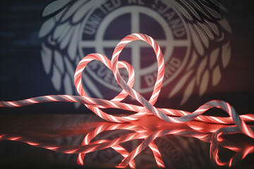 A red rope is tied in a heart shape. The rope is next to a logo that says United We Stand