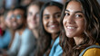 © MikeLegend - Group of smiling young adults seated in a row, focus on woman in foreground.
