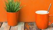 © TOWTOW Studio - Bright orange coffee mug and plant pot on rustic wooden surface against matching background for vibrant home decor inspiration.