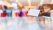 © Anna - Hand holding credit card in bright shopping mall with blurred colorful background