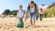 © lililia - A boy wearing a green jacket diligently picks up litter from the beach, surrounded by others participating in a community cleanup to enhance environmental efforts and protect marine life