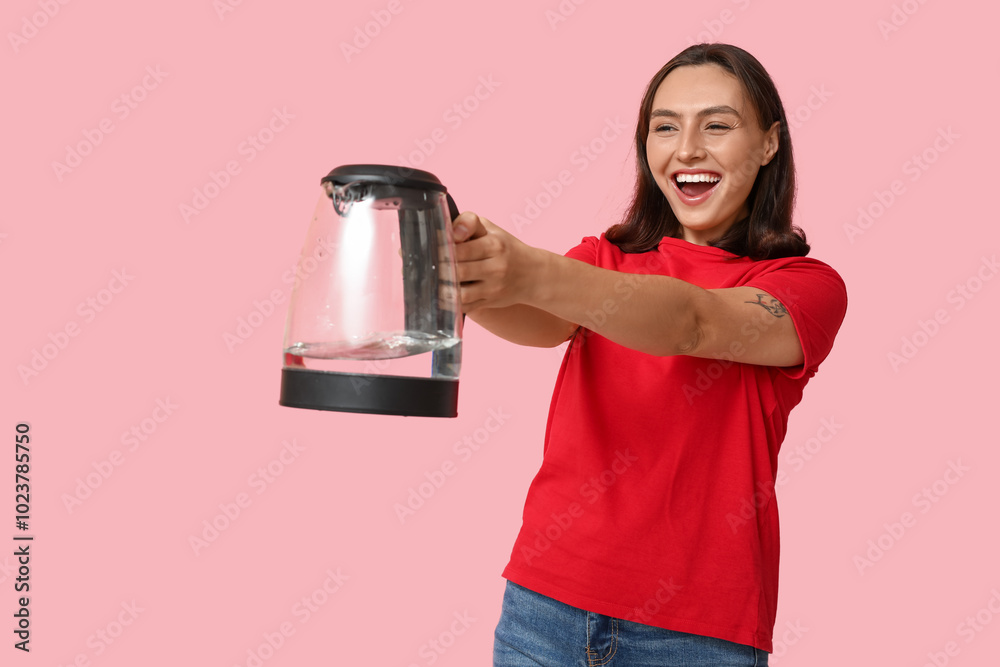 Happy young woman with modern electric kettle on pink background