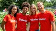 © Anna - Four enthusiastic volunteers in red вЂњVolunteerвЂќ shirts smile as they collaborate in a sunlit community gardening event, promoting teamwork and environmental care