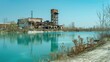 © Rodica - An old, abandoned factory building with a tall chimney reflects on the calm surface of a river, surrounded by autumn trees and a cloudy sky, symbolizing decay and industrial past