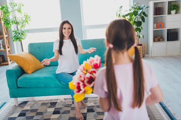 Poster - Photo of happy family cute daughter greeting her mom mother day fresh tulips time together indoors in cozy living room