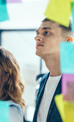 Smiling cheerful female entrepreneur writing funny information on paper stick while enjoying cooperation with male entrepreneur colleagues, multicultural people creating new strategy for proud ceo