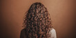 © Mr. Stocker - Curly hair displayed from the back against a warm brown backdrop in a cozy indoor setting