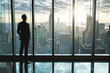 © zgurski1980 - Business man in suit in office looking at modern city with skyscrapers through panoramic window, sunrise