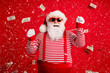 © deagreez - Photo of retired grandfather grey beard raise fists huge load money wear santa x-mas costume suspenders sunglass gloves striped shirt cap isolated red color background