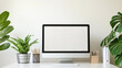 © Kateryna - A clean and minimalist desktop setup featuring a white desk against a neutral wall with a sleek computer screen in the center. The scene includes small, neatly arranged office deco