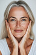 © MaxStock - Smiling mature woman touching her face