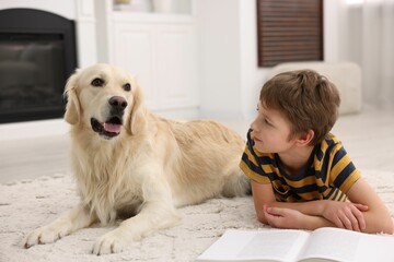 Canvas Print - Boy reading book with his cute dog at home